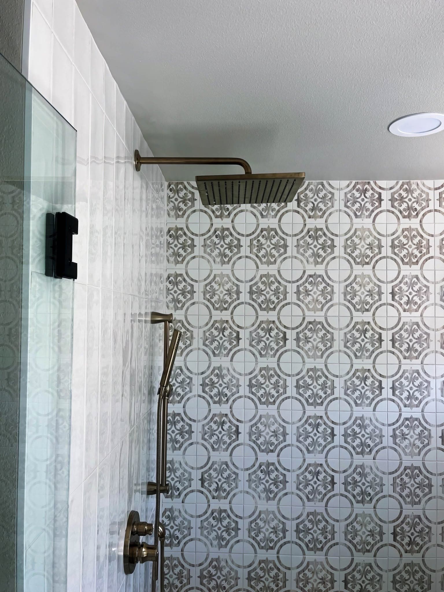 Custom tile pattern with decorative encaustic-style medallion tile on a shower wall